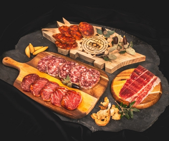 Decoración navideña de una tabla de embutidos con pan, bellotas y hojas de encina